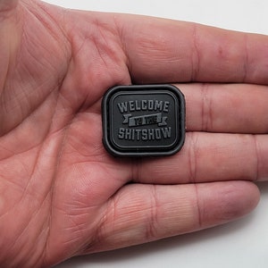 Pu&ograve; includere: Toppa quadrata nera con il testo "Welcome to the Shitshow" in lettere bianche.