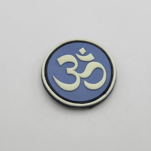 May include: A blue round sticker with a white Om symbol in the center.