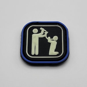 May include: A blue and white patch with a white outline of two figures, one pouring a drink into the other's mouth. The patch has a black background and a blue border.