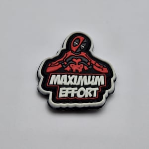 以下が含まれることがあります： 漫画のキャラクターと「MAXIMUM EFFORT」というテキストが書かれた、黒、白、赤の刺繍パッチです。