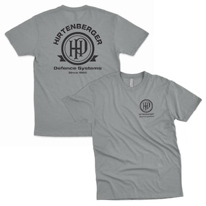 May include: A gray t-shirt with a black logo on the back. The logo is a circle with the text "Hirtenberger Defence Systems Since 1880" and a stylized "HP" inside the circle. The front of the shirt has a smaller version of the logo in the center.