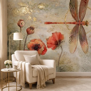 May include: A wall mural featuring a large dragonfly with translucent wings centered in a gold circle, surrounded by orange poppy flowers and seed pods on a textured, light-colored background with gold leaf accents, positioned behind a cream armchair.