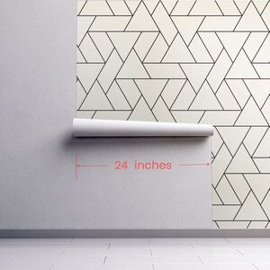 May include: A roll of white wallpaper with a black geometric pattern of overlapping triangles. The wallpaper is 24 inches wide.