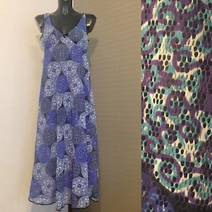 May include: A blue and white sleeveless dress with a floral pattern. The dress has a V-neckline and a flowy skirt.