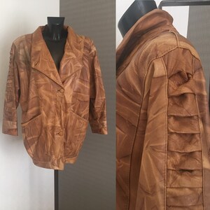 May include: A brown leather jacket with a textured design. The jacket has a button closure, two pockets, and long sleeves.