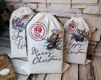 May include: Three off-white Christmas gift bags with embroidered designs. One bag features an angel, another a reindeer, and the third a bell. Each bag has the words "Joy", "Merry Christmas", and "Happy Christmas" in script. The bags have a drawstring closure.