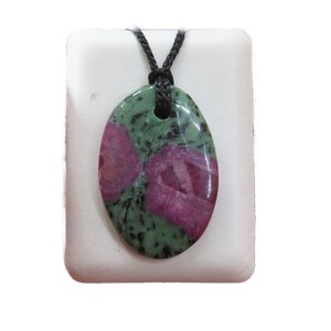 Può includere: Un ciondolo ovale verde e rosa con un cordoncino nero. Il ciondolo è fatto di una pietra naturale con un motivo unico.