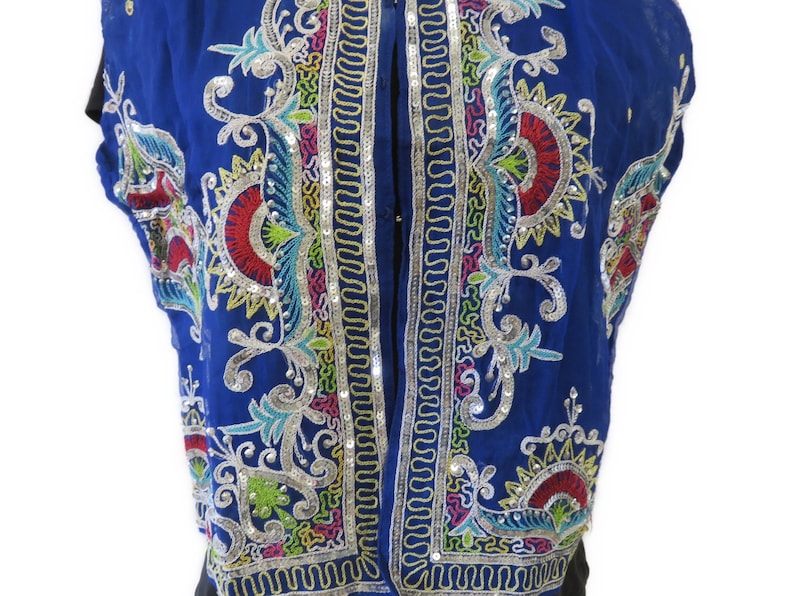 May include: A blue sleeveless vest with colorful embroidery and sequins. The embroidery features floral and geometric patterns.