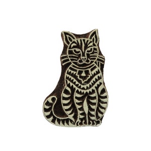Op de afbeelding: Een houten bloksnede van een kat met een gedetailleerd ontwerp. De kat zit met gekruiste poten en heeft een gepatroneerd lichaam en gezicht.