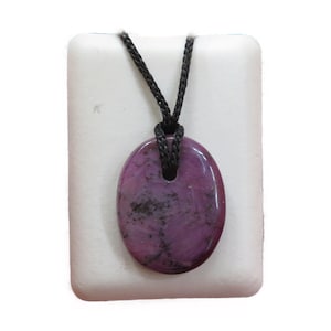 Könnte beinhalten: Ein ovaler Anhänger in Lila und Schwarz mit einer schwarzen Schnurkette.