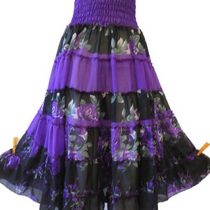 Könnte beinhalten: Ein mehrlagiger Rock in Lila und Schwarz mit Blumenmuster. Der Rock hat einen Rüschen-Saum und einen elastischen Bund.