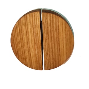 Può includere: Una maniglia per porta in legno con un design unico diviso. La maniglia è composta da due semicerchi che si incastrano per creare un cerchio completo.