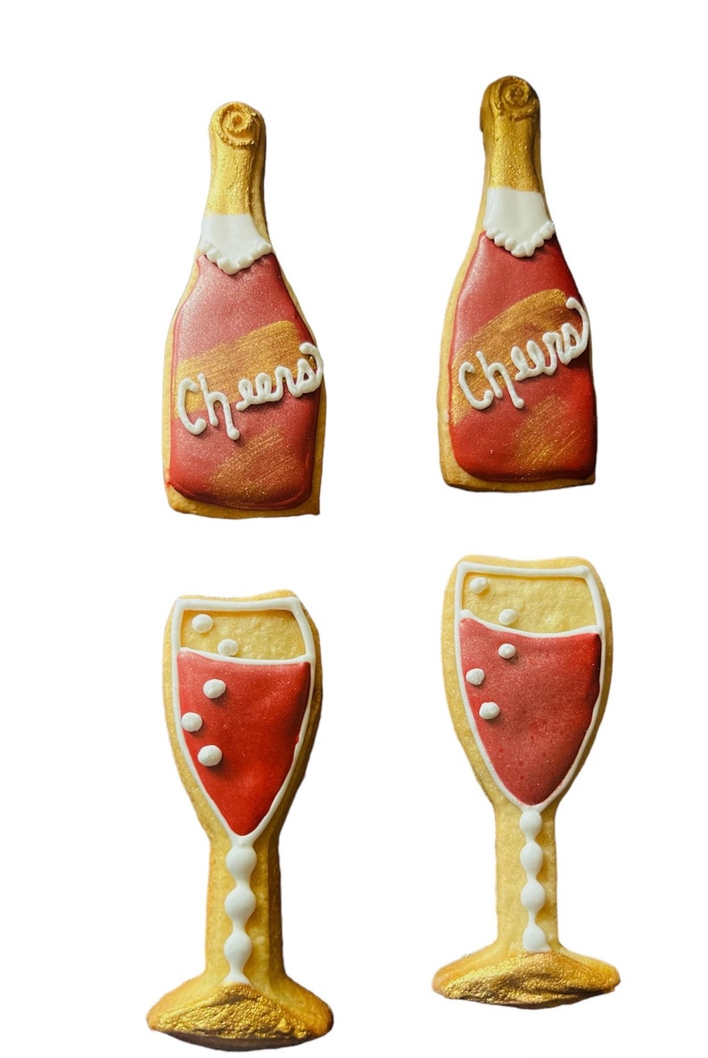 K&ouml;nnte beinhalten: Vier dekorierte Kekse in Form von Champagnerflaschen und -gl&auml;sern. Die Flaschen sind rot mit goldenen Akzenten und dem Wort "Cheers" in wei&szlig;em Zuckerguss. Die Gl&auml;ser sind mit roter Fl&uuml;ssigkeit gef&uuml;llt und haben wei&szlig;e Blasendetails.
