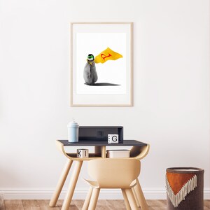 May include: A framed illustration of a penguin wearing a yellow cape with a red letter 'P' on it. The penguin is wearing a green and black mask. The illustration is on a white background.