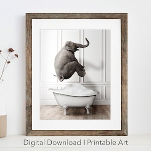 Puede incluir: Una lámina de arte enmarcada con una fotografía en blanco y negro de un elefante gris saltando dentro de una bañera blanca con patas de garra llena de espuma. La obra está en un marco de madera marrón rústico con un paspartú de color blanco.
