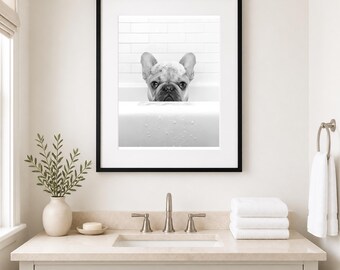 May include: A black and white framed wall art print featuring a French Bulldog with soap suds on its head, peeking over the edge of a white bathtub. The background shows white subway tiles. The print is enclosed in a simple black frame.