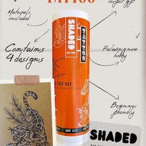 Könnte beinhalten: Eine orangefarbene und weiße SHADED ART KITS-Tube mit dem Wort "TATTOO" in Orange. Die Tube enthält 4 Designs und beinhaltet Materialien. Eine Zeichnung eines Tigers wird auf braunem Papier angezeigt. Das Kit ist anfängerfreundlich.