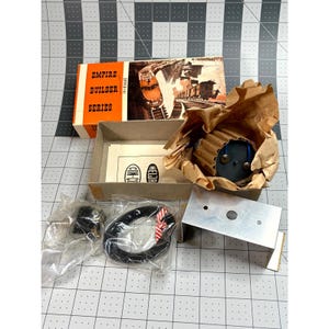 May include: An open box set with the words "EMPIRE BUILDER SERIES" in orange and black. The set includes a small motor, wiring, and a metal plate. The box has an illustration of a train.