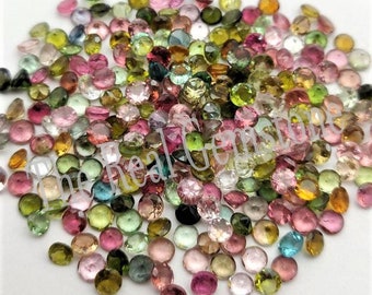 Puede incluir: Una colección de gemas coloridas en varios tonos de rosa, verde, amarillo y azul. Las gemas son redondas y facetadas, con una superficie pulida y reflectante. La imagen muestra una variedad de tamaños y tonalidades, creando una exhibición vibrante.