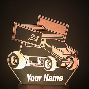 May include: A white acrylic night light shaped like a race car with the number 24 on the side. The light has a personalized name, "Your Name", at the bottom.