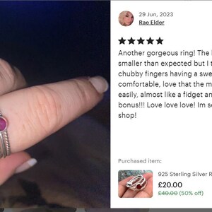 May include: A set of three silver rings, one with a red gemstone. The rings are stacked on a finger. The caption reads "Another gorgeous ring! The hammered ring is slightly smaller than expected but I think that was more my chubby fingers having a swell day! Super comfortable, love that the middle ring moves so easily, almost like a fidget anxiety ring. Added bonus!!! Love love love! Im seriously hooked on this shop!"  The text "925 Sterling Silver Ring, Ruby Gemstone Ring, W... &pound;20.00 &pound;40.00 (50% off)" is also visible.