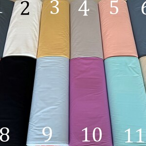 May include: Twelve rolls of fabric in various colors, numbered 1 through 12. The colors include gray, white, yellow, light gray, pink, blue, black, light blue, purple, turquoise, and beige.