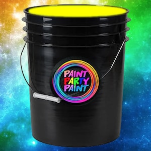May include: A black plastic bucket filled with bright yellow paint. The bucket has a handle and a label that says "Paint Party Paint" with a rainbow circle around the text.