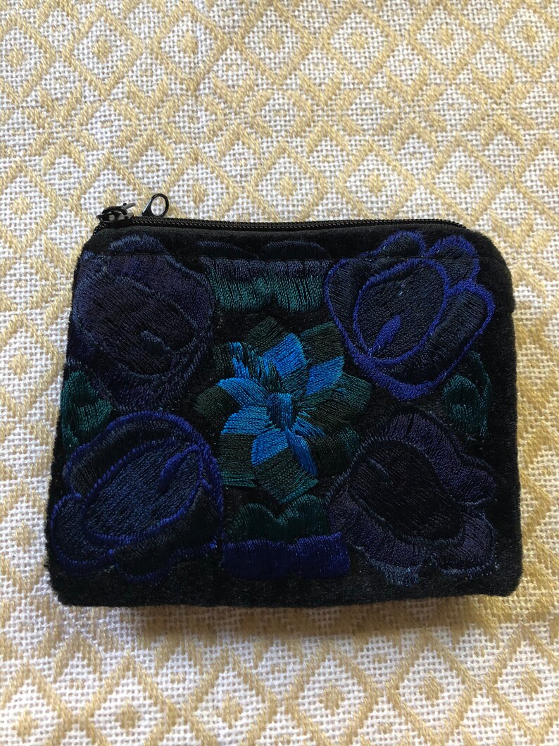 May include: A black velvet zippered pouch with embroidered blue and green floral designs.