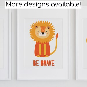 May include: Three framed prints featuring colourful illustrations of a giraffe, a lion, and a bee. The giraffe is yellow with brown spots and the text "Stand Tall". The lion is orange with a yellow mane and the text "Be Brave". The bee is yellow and black with blue wings and the text "Be Happy".