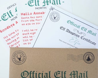 May include: A brown paper envelope with a green and white "Official Elf Mail" label. The envelope is addressed to Annabelle. The envelope has a red and white reindeer stamp and a green and white Christmas tree stamp.