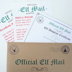 May include: A brown paper envelope with a green and white "Official Elf Mail" label. The envelope is addressed to Annabelle. The envelope has a red and white reindeer stamp and a green and white Christmas tree stamp.
