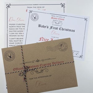 May include: A brown kraft paper envelope tied with red, green, and white twine, labelled Official Christmas Express Delivery for Oliver. Behind it, a white certificate from Santa Claus confirms Baby's First Christmas for Oliver on the Nice List.