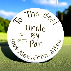 May include: A white golf ball featuring black engraved text that reads To The Best Uncle BY Par, accompanied by a small graphic of a golf flag on a green. The bottom of the ball includes the engraved text love Alex, John, Alice.