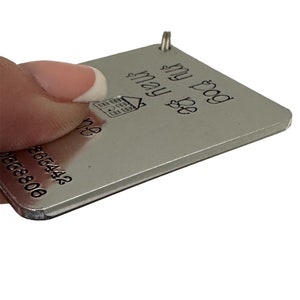 May include: Silver keyring with the text "Be my guest & play" and a house icon. The back of the keyring has a phone number.