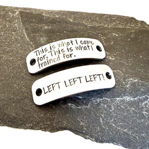 May include: Two curved, rectangular silver-toned metal tags with rounded corners and holes on each end. The top tag is engraved with the text: This is what I came for. This is what I trained for. The bottom tag is engraved with: LEFT LEFT LEFT!
