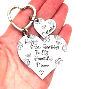 May include: Silver heart-shaped keychain with the text "Happy 21st Birthday To My Beautiful Niece" and a smaller heart-shaped charm with the name "Natasha" engraved on it.