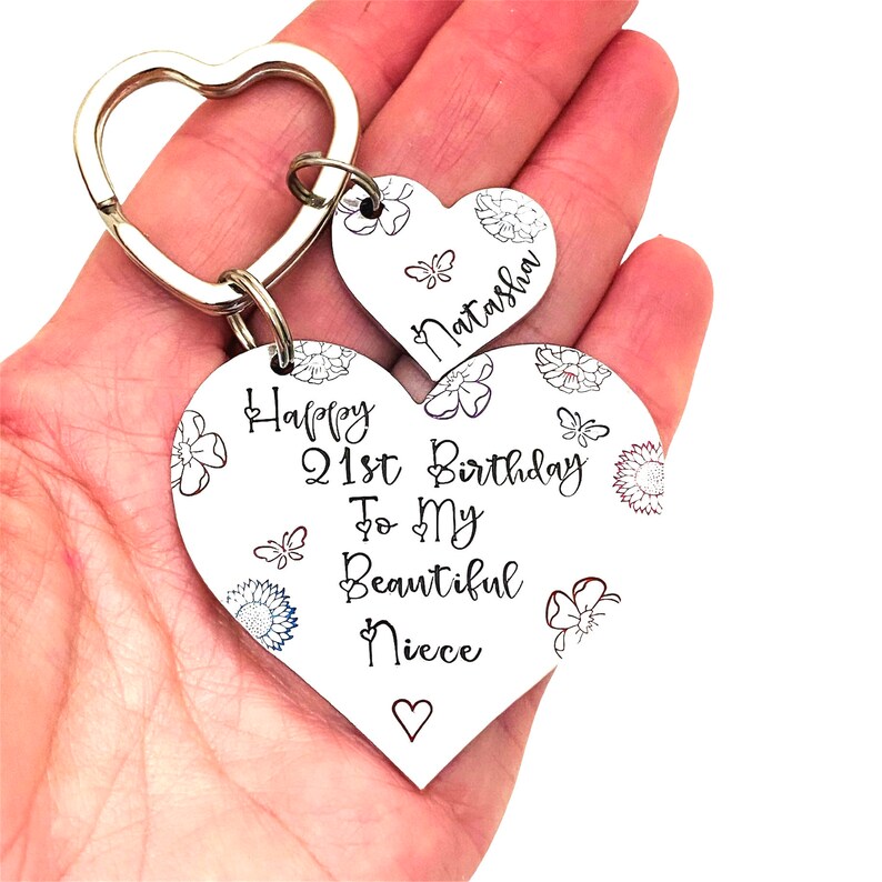 May include: Silver heart-shaped keychain with the text "Happy 21st Birthday To My Beautiful Niece" and a smaller heart-shaped charm with the name "Natasha" engraved on it.