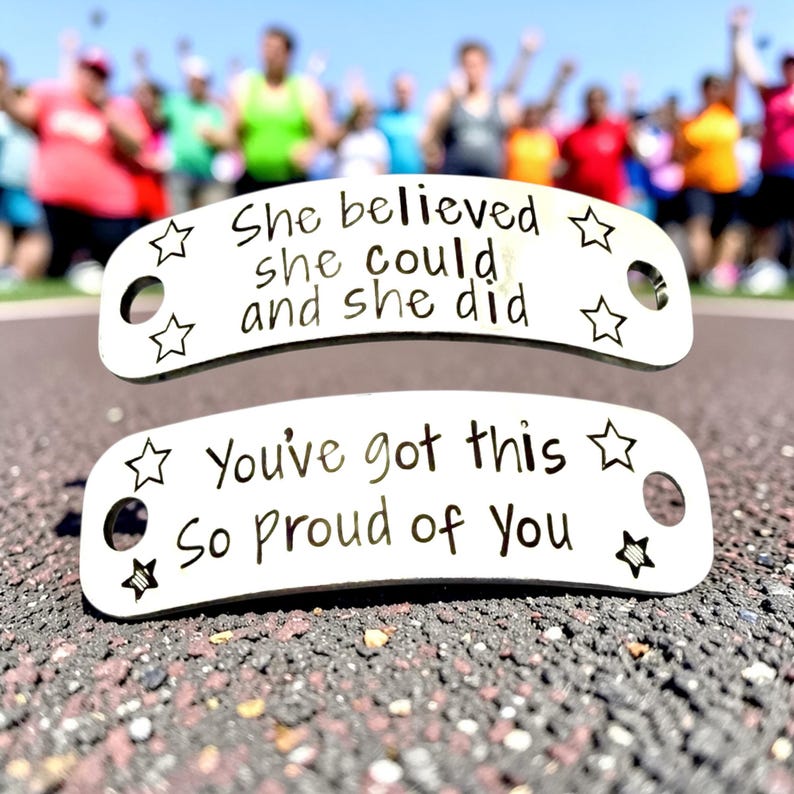 May include: Two silver metal shoe tags with motivational phrases. The top tag reads "She believed she could and she did" and the bottom tag says "You've got this So proud of You". Each tag has star designs.