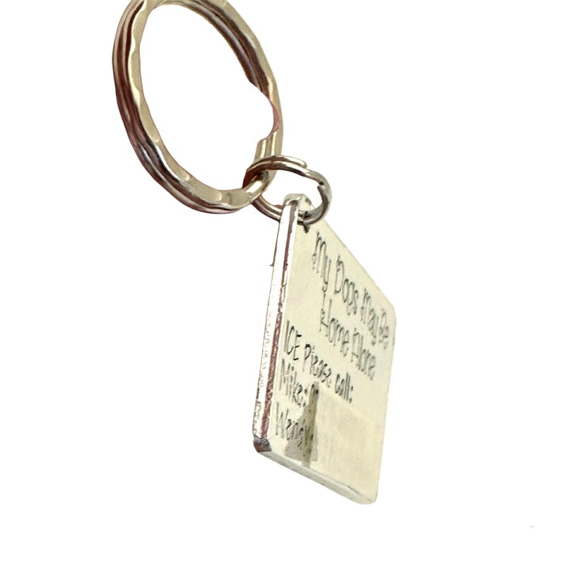 May include: Silver keyring with a square tag that reads "My Dogs May Be Home, But I'm Here.  ICE Please call: Mike: ... Wanda: ..."