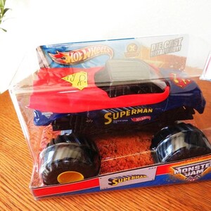 May include: A Hot Wheels Superman monster truck toy in a clear plastic package. The truck is blue with a red hood and the Superman logo. The packaging includes the words "Superman", "Hot Wheels", and "Monster Jam".
