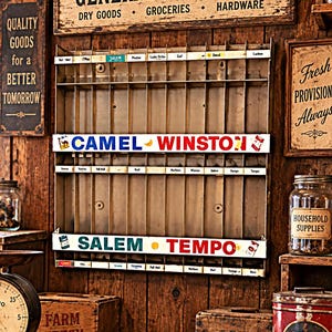 May include: A vintage metal display rack featuring multiple vertical slots for product organization. The rack includes horizontal white labels with brand names like Camel, Winston, Salem, and Tempo printed in various colors across the front.
