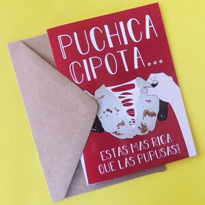 May include: Red card with white text that reads "Puchica Cipot... Estas mas rica que las pupusas!"  The card features a cartoon image of a hand tearing a piece of food.