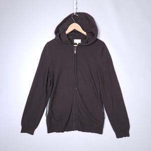 May include: A brown hooded zip-up sweater with a long sleeve.