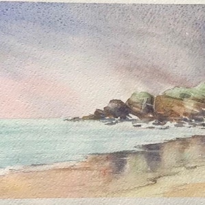 May include: Watercolour painting of a rocky coastline with a sandy beach and a blue sea. The sky is a soft purple and pink, with clouds casting shadows on the water. The painting is signed "Beach Sands" in the bottom left corner.
