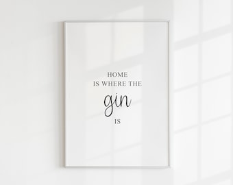 Puede incluir: Impresión enmarcada en blanco con el texto "Home is where the gin is" en fuente cursiva negra.