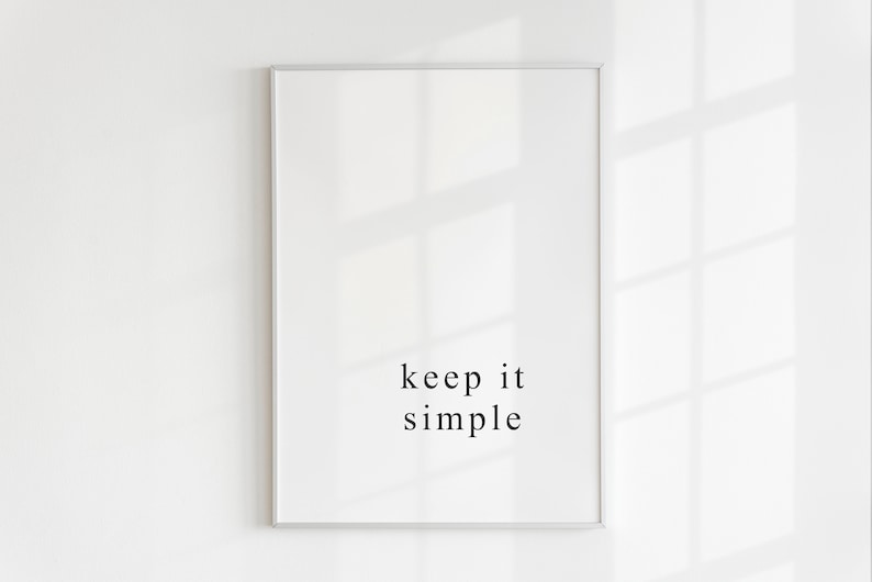 K&ouml;nnte beinhalten: Ein wei&szlig;er gerahmter Druck mit dem Text "keep it simple" in schwarzen Buchstaben.
