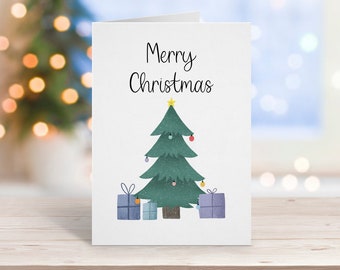 Puede incluir: Una tarjeta blanca con el texto "Feliz Navidad" en letras cursivas negras. Debajo del texto se ilustra un árbol de Navidad verde con una estrella amarilla en la cima. El árbol tiene adornos rojos y blancos y luces amarillas. Tres regalos envueltos en azul y blanco están en la base del árbol.
