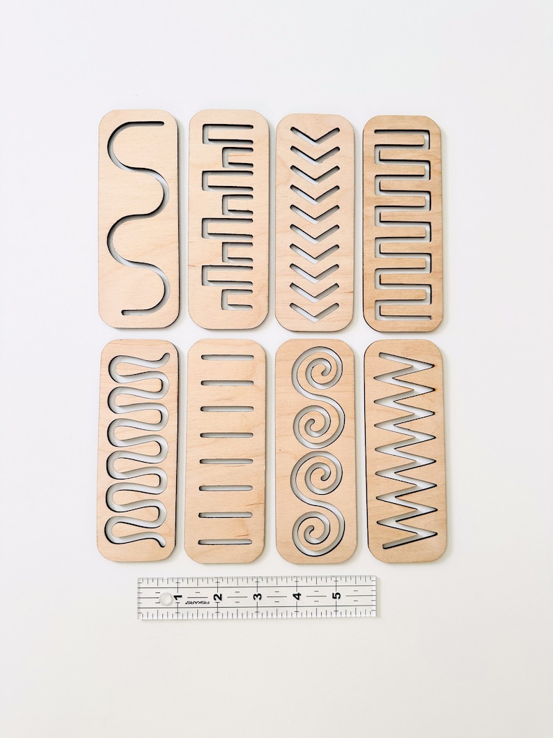 May include: Eight wooden strips with different patterns cut out. The strips are approximately 5 inches long and 1 inch wide. The patterns include wavy lines, rectangles, chevrons, and spirals.