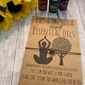 May include: A brown card with the text "I run on yoga and essential oils" and a silhouette of a person in a yoga pose. The card also includes the text "Aromatherapy lava bead essential oil diffuser. Put it on your wrist & make a wish! It will start to come true when it falls off of you!" and "Alyssa Ashley Designs".