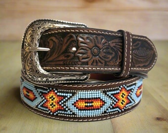 May include: A brown leather belt with a silver buckle and a beaded design. The buckle has a floral pattern and the beaded design is in shades of blue, orange, and yellow.